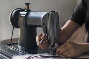 mujer con tela en máquina de coser vintage foto