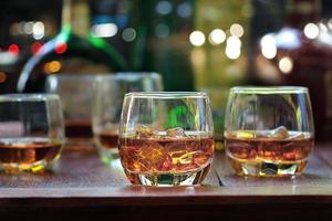 whiskey drinks with ice on wooden background photo