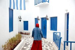 mujer musulmana posando frente a la casa tradicional blanca de grecia en santorini foto