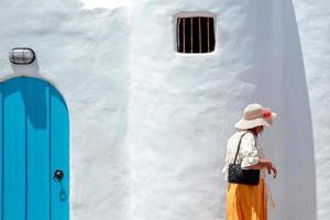 mujer turista caminando frente a la casa griega tradicional de santorini foto