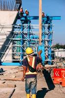 trabajador de la construcción que usa equipo de protección de seguridad y casco durante el trabajo en el sitio de construcción. bandung, indonesia-marzo 17, 2022 foto