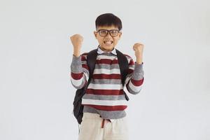 Happy Asian elementary school kid excited by doing win gesture photo