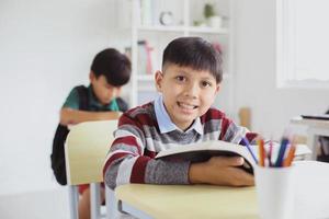 Smiling Asian student looking to the camera during a lesson in classroom photo