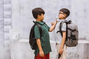 Asian boy student getting bullied in school or Children fighting or attacked their classmate in school photo