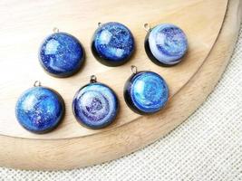 Create galaxy drink coasters using resin, glitter and pigment powders, handmade items. Suitable for keychains, necklace and pendant. photo