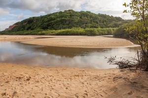 río que desemboca en la playa de taipe cerca de arraial d ajuda, bahia, brasil foto