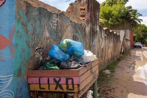 trancoso, bahia, brasil-marzo 10 2022 basura arrojada en un contenedor de madera desbordante al costado de la carretera. foto