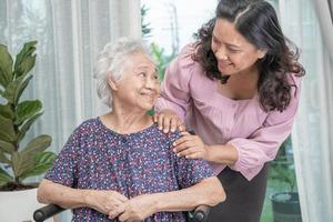 Help Asian senior or elderly old lady woman sitting on wheelchair and wearing a face mask for protect safety infection Covid 19 Coronavirus. photo