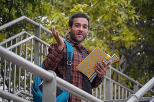 A college student is very happy having books and bag student holding books images photo