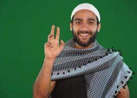 muslim boy saying hello on Green screen background. photo