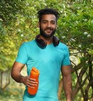 Healthy man with protein drink in shaker at Park in Morning photo