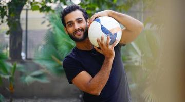 niño de 25 años sosteniendo un balón de fútbol foto