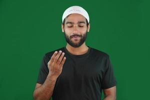 niño musulmán rezando en el fondo de la pantalla verde. foto