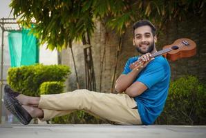 guapo joven mujer tocando el ukelele foto