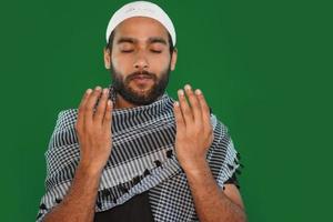 hombre religioso musulmán indio rezando sobre fondo de pantalla verde. foto
