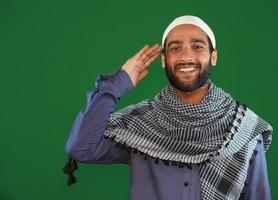 Indian muslim boy saluting on Green screen background. photo