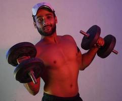 Man Lifting Weights in neon light photo