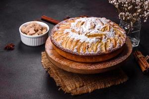 Apple pie with fresh fruits on a wooden table photo