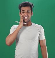 Man brush up his teeth and having teeth pain problem photo