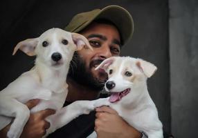 un joven amante de los perros con 2 perros felices y sonrientes - imagen de enfoque selectivo foto