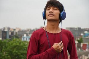 hombre asiático con auriculares escuchando música foto