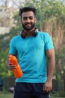 Healthy man with protein drink in shaker at Park in Morning photo