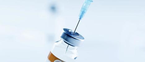 Medical syringe with a needle and a bollte with vaccine. photo