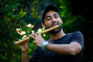 man playing flute in beautiful background photo