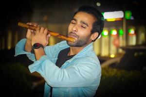 un joven tocando la flauta y disfrutando mientras toca foto