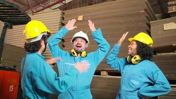 equipe de trabalhadores de engenheiros multirraciais em uniformes de segurança capacetes comemoram, mãos levantadas juntas, felizes e alegres, trabalhos da indústria bem-sucedidos, conquista, fábrica de fabricação de técnicos profissionais.