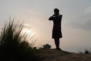 man in evening near sun standing photo