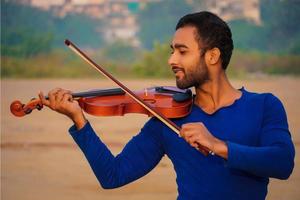 músico tocando violín. concepto de música y tono musical. imágenes de silueta de hombre músico foto