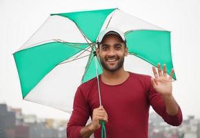 man with umbrella portrait of a handsome indian man photo