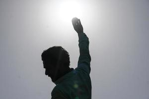 Indian bowler in action of catching ball in cricket match photo