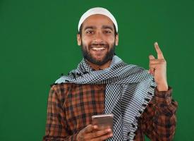 Indian muslim boy with mobile on Green screen background. photo