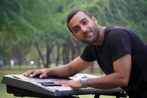 Young passionate man playing electric piano stock photo