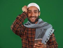 Indian muslim religious man received an exiting news on Green screen background. photo