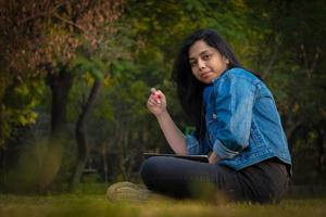 Indian student at college campus full size image reading books and watching camera photo