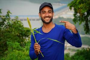 young handsome farmer with plant photo