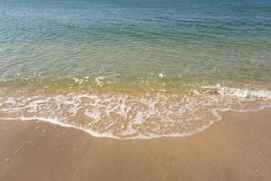 Soft ocean wave of blue ocean on tropical sandy beach in summer background with copy space. texture Background photo