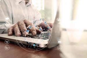 businessman hand working with modern laptop computer in modern office with virtual icon diagram photo