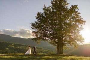 Wedding photography in the mountains. The bride and groom hug tightly. photo