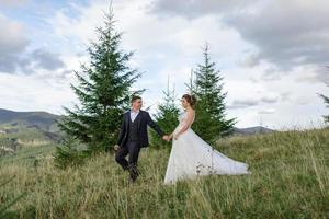 Wedding photography in the mountains. The bride and groom hug tightly. photo