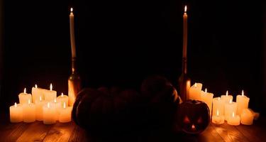 Halloween pumpkin on the background of candles and a black background.