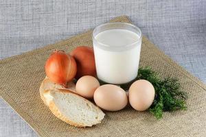 Chicken eggs with slices of bread on the table with milk photo