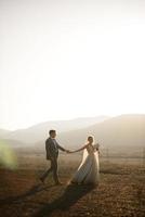 Wedding photo session of the bride and groom in the mountains. Photoshoot at sunset.
