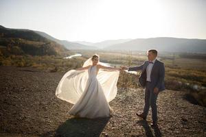 Wedding photo session of the bride and groom in the mountains. Photoshoot at sunset.