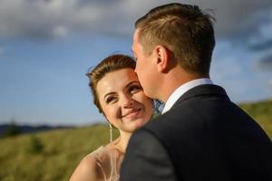 Wedding photography in the mountains. The bride and groom hug tightly. photo