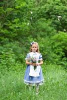 retrato de una niña linda vestida como alice. sesión de fotos estilizada en la naturaleza.