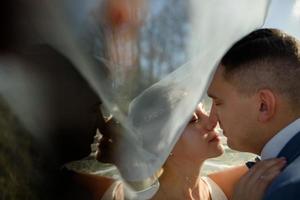 Young beautiful bride take shelter under a photo. Bright backlight shines in the frame photo
